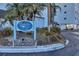 Community signage with address range, landscaping, and partial view of the building at 5830 Midnight Pass Rd # 502, Sarasota, FL 34242