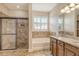 Bright bathroom with glass shower, soaking tub, granite countertops, and dual sinks at 6630 Horned Owl Pl, Sarasota, FL 34241