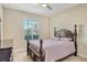 Comfortable bedroom featuring neutral walls, a four-poster bed, and a sunlit window at 6630 Horned Owl Pl, Sarasota, FL 34241