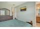 Bedroom featuring light green walls, a TV, dresser, and view into the bathroom at 6630 Horned Owl Pl, Sarasota, FL 34241