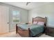This cozy bedroom features a wood frame bed, a window with shutters, and soft, neutral paint at 6630 Horned Owl Pl, Sarasota, FL 34241