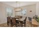Bright dining room featuring stylish chandelier, neutral colors, and sunlit windows with custom shutters at 6630 Horned Owl Pl, Sarasota, FL 34241