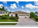 Charming single-story home featuring a three-car garage, terracotta tile roof, and lush tropical landscaping at 6630 Horned Owl Pl, Sarasota, FL 34241