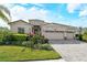 Attractive single-story home showcasing a three-car garage and well-manicured tropical landscaping at 6630 Horned Owl Pl, Sarasota, FL 34241
