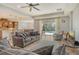 Bright and open living room with tile floors, ceiling fan, and sliding doors to the outdoor pool area at 6630 Horned Owl Pl, Sarasota, FL 34241
