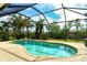 Beautiful in-ground pool surrounded by lush landscaping and a screened enclosure at 6630 Horned Owl Pl, Sarasota, FL 34241