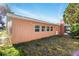 Low angle view of single story home with white windows and manicured lawn at 1741 Font Ln, Holiday, FL 34691