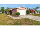 Quaint single-story home with manicured garden beds and an attached two-car garage at 1741 Font Ln, Holiday, FL 34691