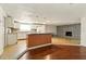 An open-concept living room and kitchen with stone fireplace creates a inviting space at 1741 Font Ln, Holiday, FL 34691