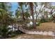 Wooden dock with concrete steps extending onto the river with palm trees and lush vegetation at 3826 E 155Th E Ave, Parrish, FL 34219
