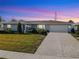 Charming single-story home with well-manicured lawn and attached two-car garage against a vivid sunset backdrop at 6708 Keystone Dr, Sarasota, FL 34231