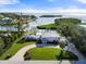 Stunning waterfront home featuring lush landscaping, circular driveway, and beautiful bay views at 7056 Hawks Harbor Cir, Bradenton, FL 34207