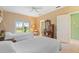 Sunny bedroom with ceiling fan, neutral walls, and a large window looking out to lush landscaping at 7056 Hawks Harbor Cir, Bradenton, FL 34207