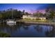 Exterior view of waterfront estate at dusk showcasing private dock and lush lawn at 7056 Hawks Harbor Cir, Bradenton, FL 34207