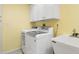 Functional laundry room featuring modern appliances, a utility sink, and ample storage space at 7056 Hawks Harbor Cir, Bradenton, FL 34207