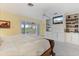 View of the main bedroom with built-in shelving, TV, and lanai access at 7056 Hawks Harbor Cir, Bradenton, FL 34207