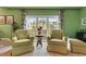Inviting sitting area features tile flooring, and natural light from the large windows overlooking the lush community at 7056 Hawks Harbor Cir, Bradenton, FL 34207