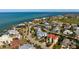 Aerial view of a coastal neighborhood featuring beautiful homes with tile roofs, lush landscaping, and golf course nearby at 718 Key Royale Dr, Holmes Beach, FL 34217