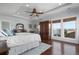 Spacious bedroom with a ceiling fan, large windows, hardwood floors, and stylish decor at 718 Key Royale Dr, Holmes Beach, FL 34217