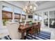Sunlit dining room with large windows, coastal decor, and access to an outdoor seating area at 718 Key Royale Dr, Holmes Beach, FL 34217