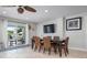 Dining area with seating for six, opens to outdoor patio with pool, and modern furnishings at 718 Key Royale Dr, Holmes Beach, FL 34217