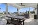 Covered outdoor patio with a dining table, ceiling fan, and a built-in kitchen for al fresco dining at 718 Key Royale Dr, Holmes Beach, FL 34217