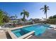 Backyard oasis featuring a pool, integrated spa, and lush landscaping for relaxing outdoors at 718 Key Royale Dr, Holmes Beach, FL 34217