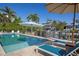 Backyard pool with ample seating, sunny skies, and lush, mature landscaping at 718 Key Royale Dr, Holmes Beach, FL 34217