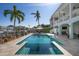 Inviting backyard pool and patio area are overlooked by a lovely covered porch with ceiling fans at 718 Key Royale Dr, Holmes Beach, FL 34217