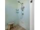 Simple shower featuring neutral-colored tiling and a wooden shower stool at 718 Key Royale Dr, Holmes Beach, FL 34217