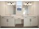 Bathroom featuring double sinks with modern fixtures and vanity space, all with white cabinets at 8528 Beechlake Ct, Sarasota, FL 34240
