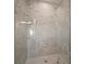Shower featuring light tile surround, glass door and chrome shower head at 8528 Beechlake Ct, Sarasota, FL 34240