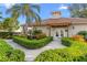 Exterior view of the clubhouse entrance framed by manicured landscaping and palm trees at 1000 San Lino Cir # 1032, Venice, FL 34292