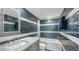 Charming bathroom with a shower-tub combo with blue textured tile and sleek marble countertop sink at 101 S Gulfstream Ave # 16J, Sarasota, FL 34236