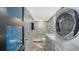 A clean and modern bathroom featuring in-unit laundry and blue patterned tile at 101 S Gulfstream Ave # 16J, Sarasota, FL 34236