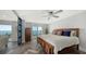 Bedroom with wood-style flooring, sliding glass doors to patio, and partial water views at 101 S Gulfstream Ave # 16J, Sarasota, FL 34236