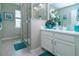 Bathroom with white cabinets, tiled glass shower, neutral colored wall paint and flooring, and decorative accents at 11728 Meadowgate Pl, Bradenton, FL 34211