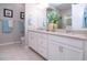 Bathroom with double vanity, granite countertops, white cabinets, and a glass-enclosed shower at 11728 Meadowgate Pl, Bradenton, FL 34211