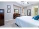 Spacious bedroom featuring carpet, ceiling fan, a large dresser and a comfortable bed with a white comforter at 11728 Meadowgate Pl, Bradenton, FL 34211