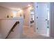 Upstairs hallway with carpet, neutral paint, wood railing, and a view of a living space through a doorway at 11728 Meadowgate Pl, Bradenton, FL 34211