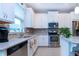 Stylish kitchen boasts white cabinets, stainless steel appliances, and a mosaic tile backsplash at 11728 Meadowgate Pl, Bradenton, FL 34211