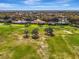 Scenic aerial perspective of homes nestled along a golf course, surrounded by verdant trees and manicured landscaping at 124 Ventana Way, Venice, FL 34292