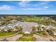 Expansive aerial view of a clubhouse, pool, and golf course showcasing beautiful landscaping, water features and surrounding greenery at 124 Ventana Way, Venice, FL 34292