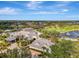 An aerial view of a clubhouse and golf course, featuring a large pool, lush landscaping, and surrounding natural beauty at 124 Ventana Way, Venice, FL 34292
