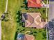 Overhead view of a property showcasing a tile roof, screened lanai, meticulously maintained landscaping, and proximity to a golf course at 124 Ventana Way, Venice, FL 34292