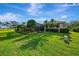 Beautifully landscaped backyard showcasing mature trees, well-manicured lawn, and a screened-in patio area at 124 Ventana Way, Venice, FL 34292