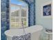 Elegant bathroom features soaking tub with blue accents and natural light at 124 Ventana Way, Venice, FL 34292