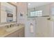 Well-lit bathroom with vanity and a glass-enclosed shower and decorative tilework at 124 Ventana Way, Venice, FL 34292