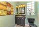 Charming powder room with a dark vanity, decorative art, and tile flooring at 124 Ventana Way, Venice, FL 34292