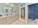 Light and airy bathroom with a light wood cabinets, spacious vanity, and unique jellyfish themed wallpaper at 124 Ventana Way, Venice, FL 34292